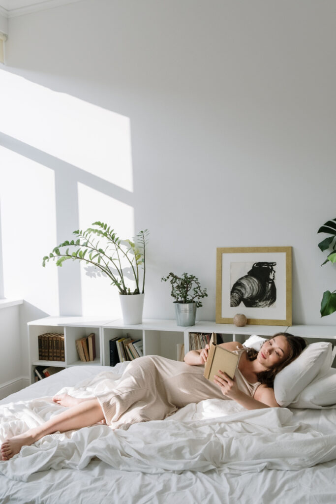woman laying in bed reading about natural remedies for pmdd