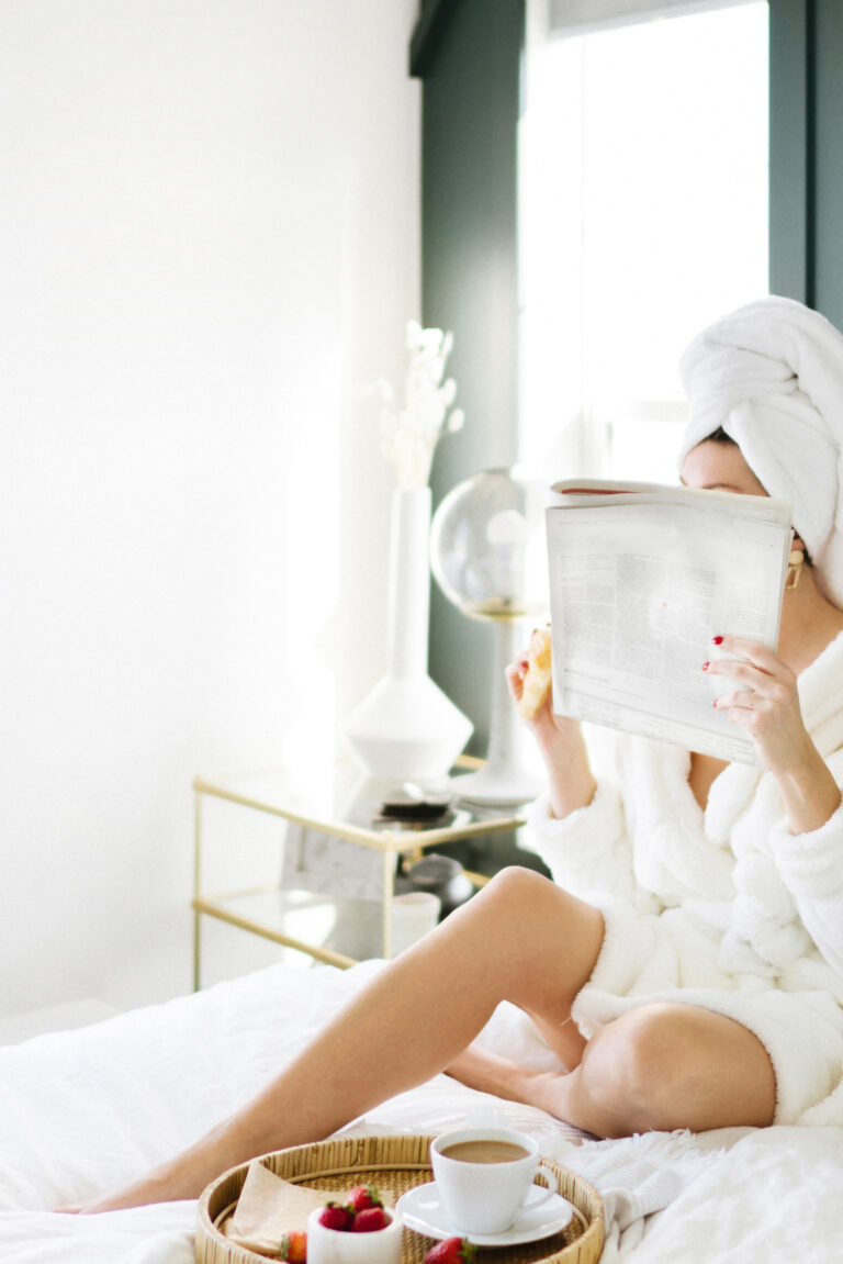 woman practicing self care drinking tea and reading a book