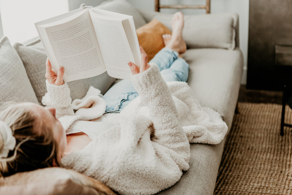 woman laying on sofa reading a book as an example of mindfulness in everyday life