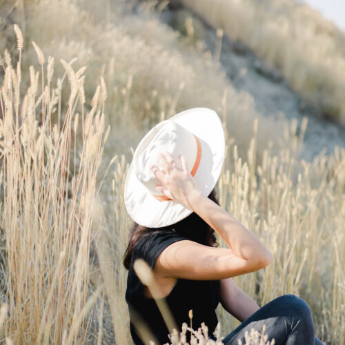 woman sitting in a field practicing mindfulness