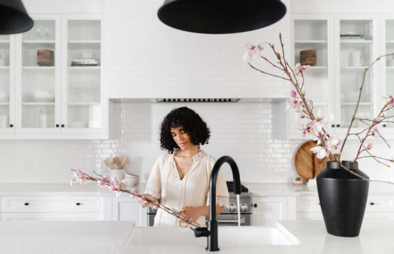 woman arranging flowers in kitchen