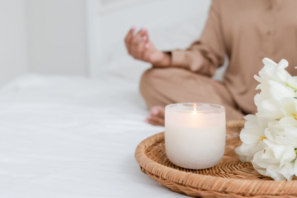 woman meditating with candle burning