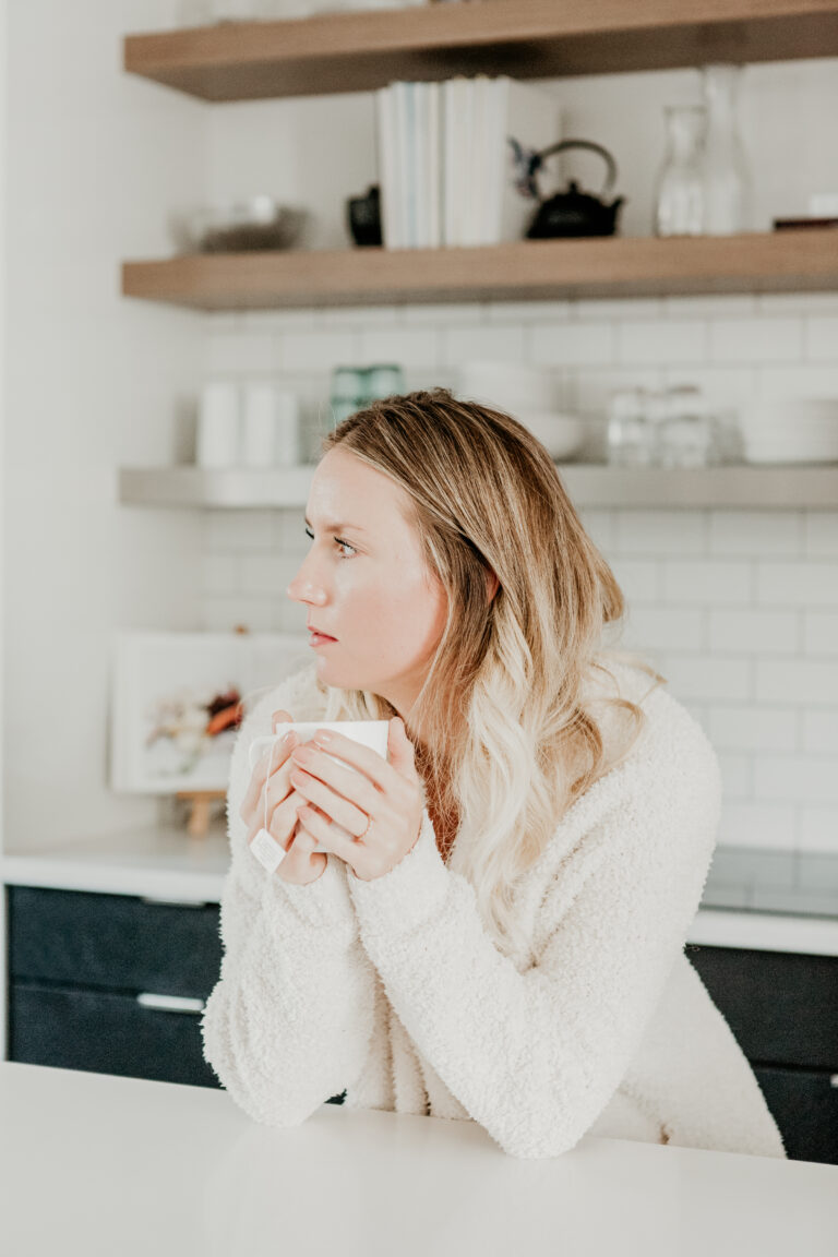 woman drinking a cup of tea trying to shut her brain off to quiet anxiety