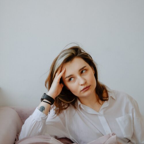 woman with hand on head looking annoyed