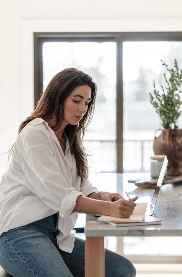 woman sitting at desk writing