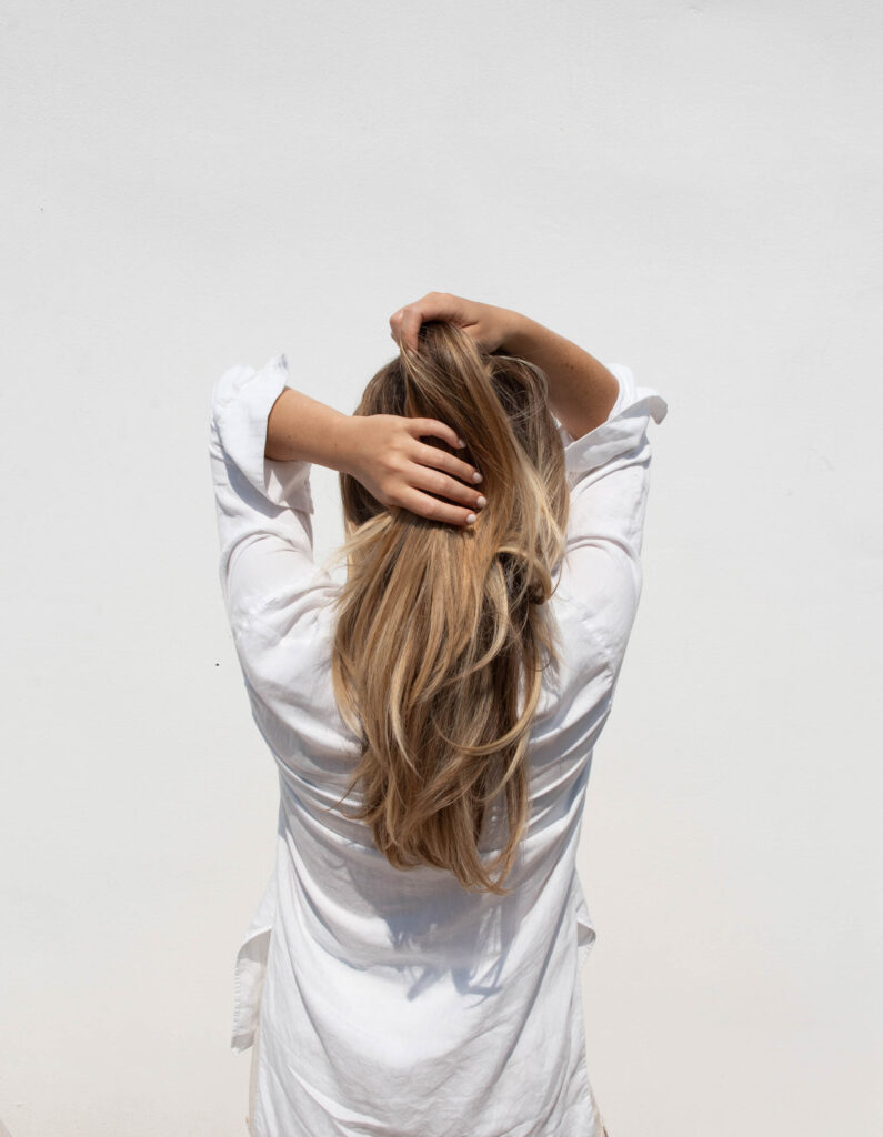 back of a woman holding her hair
